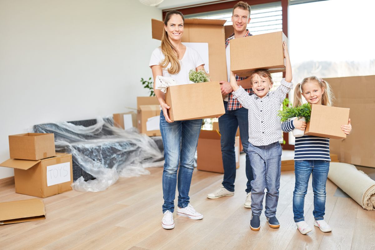 Glückliche Familie mit zwei Kindern beim Umzug in ein neues Zuhause – Symbol für Neubeginn, Ankommen und Unterstützung durch das WelcomeCenter im Landkreis Görlitz